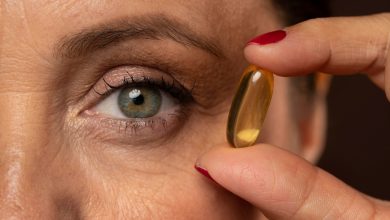 close up elder woman holding oil pill 1