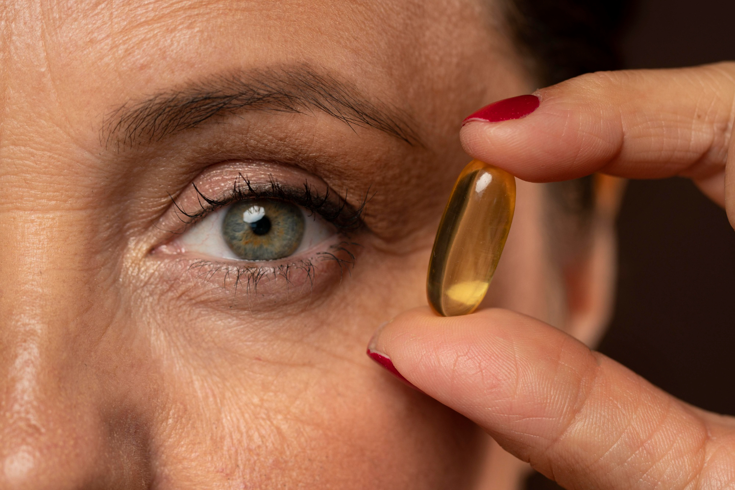 close up elder woman holding oil pill 1