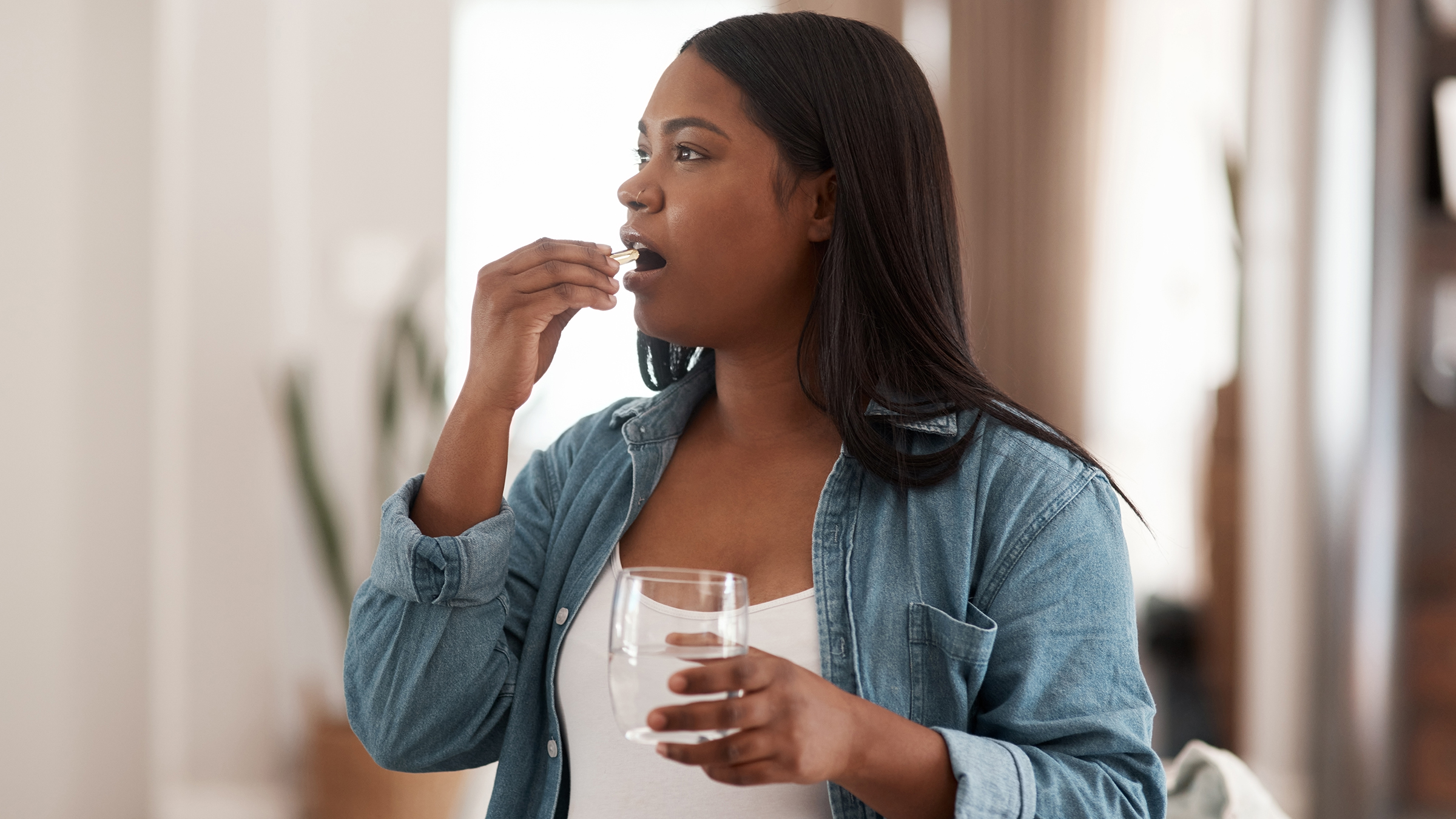 Shot of a pregnant woman taking medication at home